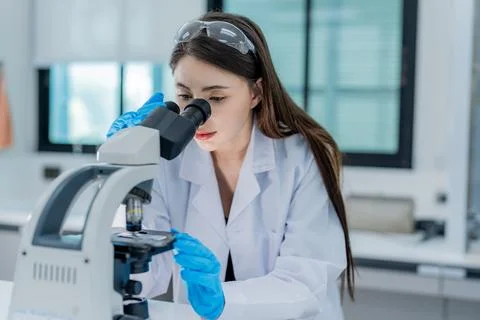 Scientist examines specimen under microscope in laboratory setting during t.. Stock Photos
