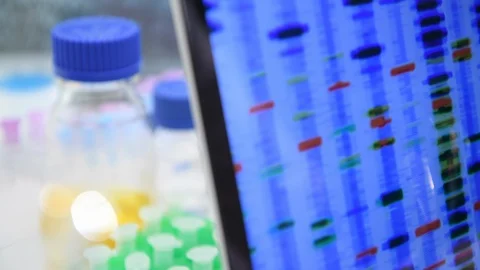 Scientist examining the genetic make up of a sample on the computer screen in 動画素材 129901589