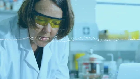 Scientist examining reagents in tech lab checking laptop comparing with waveform Stock Footage 309761631