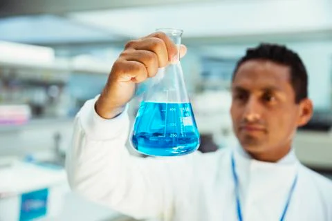 Scientist examining sample in beaker in laboratory Foto stock
