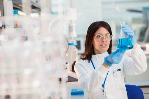 Scientist examining sample in beaker in laboratory Foto stock