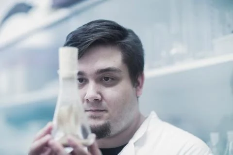 Scientist examining sample in beaker Foto stock