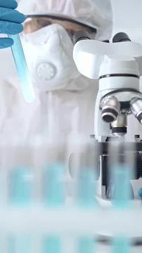 Scientist examining sample in laboratory. Professional scientist in ppe Stock Photos