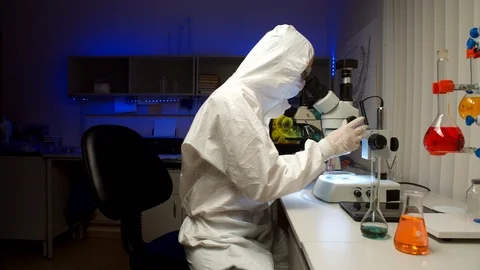 Scientist examining samples with microscope Stock Footage 127563497