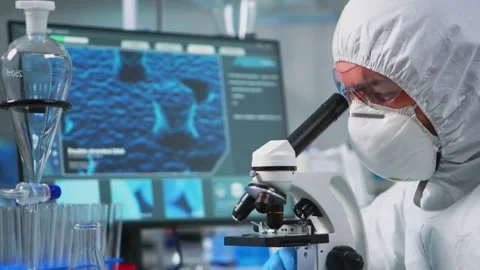 Scientist Examining Virus Samples Using Microscope in Modern Lab Stock Footage 330276210