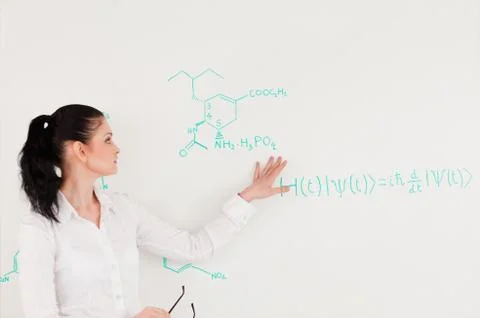 Scientist explaining a formula written on a white board 写真素材