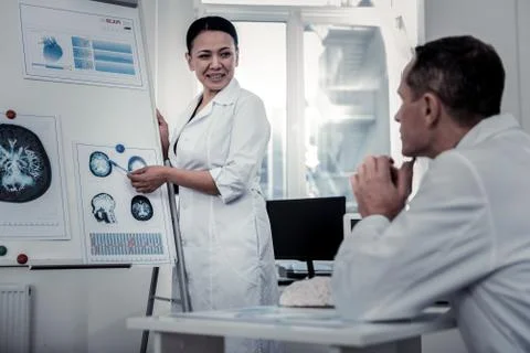 Scientist explaining the processes in brain to her colleague Foto stock