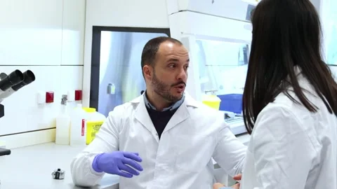 Scientist explaining research to colleague in laboratory Stock Footage 296884292