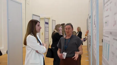 Scientist Explaining Research Poster information to a Colleague Stock Footage 334775059