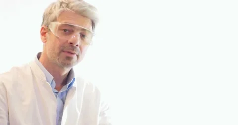 A scientist explains something about two test tubes an shows on a white wall Stock Footage 48974696