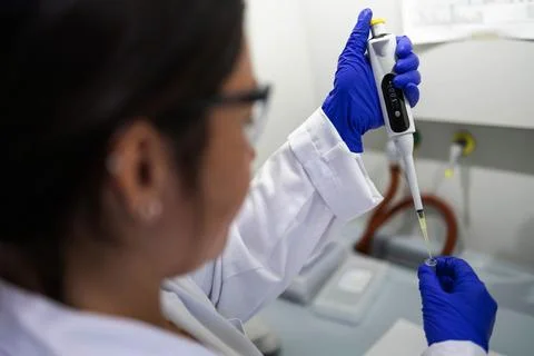 A scientist extracting a liquid sample Stock Photos