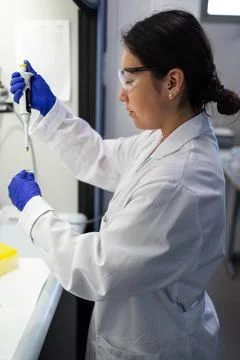 A scientist extracting a liquid sample Stock Photos
