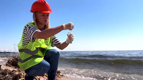 Scientist gathers water samples from sandy beach, analyzing coastal environment Vídeo Stock 336704126