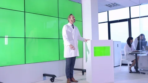 Scientist giving lecture in front of green screen display in office Stock Footage 108181597
