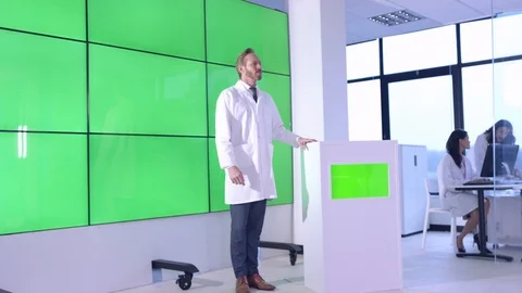 Scientist giving lecture in front of green screen display in office Stock Footage 108182181