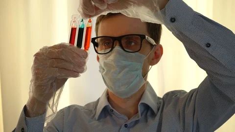 Scientist with Glasses Examines Test Tubes Video stock 128321355