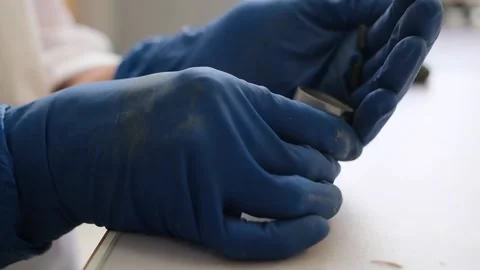 A scientist in gloves puts soil samples into a container for research. Clay Stock Footage 231739692