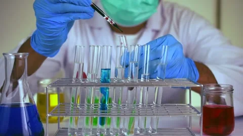 Scientist hand holding pipette dropping a sample into a test tube. Stock Footage 139735015