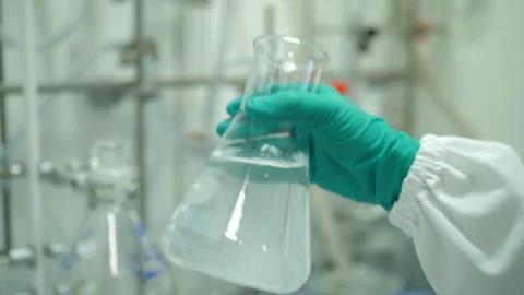 Scientist hand shaking Erlenmeyer flask in laboratory slow motion 4k Video stock 142490633