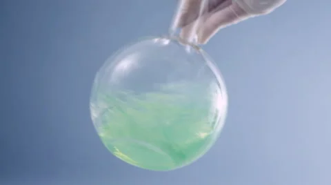 Scientist hand shaking volumetric flask with green substance HD Stock Footage 2804756