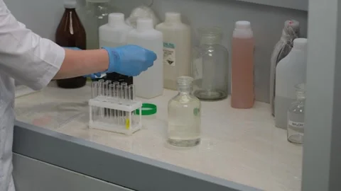 Scientist Handling Test Tubes in Laboratory Experiment Stock Footage 303369374