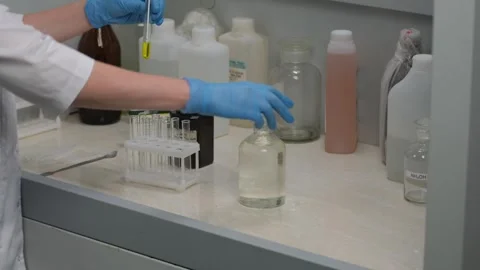 Scientist Handling Test Tubes in Laboratory Experiment Stock Footage 303369391