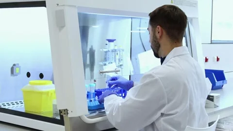 Scientist handling test tubes in a sterile laboratory environment Stock Footage 296884334