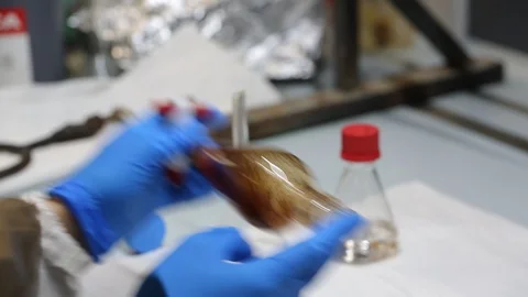Scientist hands shaking a separating funnel with a liquid extract Stock Footage 115930558