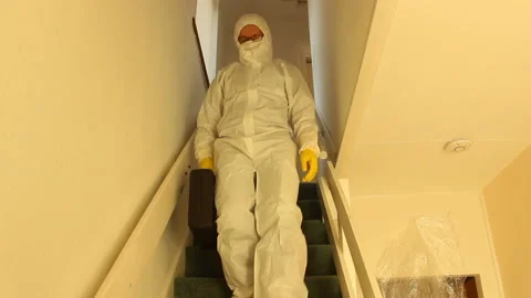 Scientist in hazmat suit going down stairs with a suitcase-protection zone Stock Footage 135721994