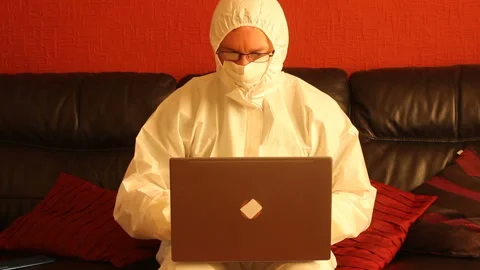 Scientist in hazmat suit working on a computer and thinking/processing data Stock Footage 135722402