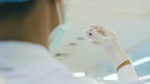 Scientist hold transparent solution in small bottle in laboratory Video stock 158527485