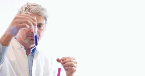 A scientist holding and looking at two test tubes and shows on the wall Stock Footage 48975425