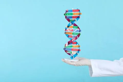 Scientist holding DNA structure model on light blue background, closeup. Sp.. Stock Photos