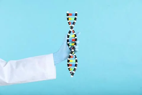 Scientist holding DNA structure model on light blue background, closeup. Sp.. 스톡 사진