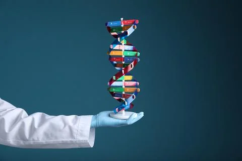 Scientist holding DNA structure model on dark blue background, closeup Stock Photos