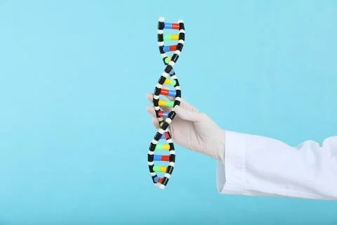 Scientist holding DNA structure model on light blue background, closeup Stock Photos