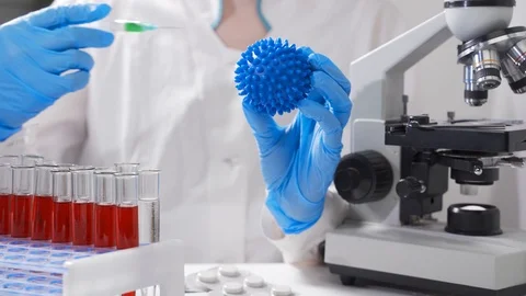 A scientist is holding a model of the virus in his hands and is testing a new Video stock 124458003