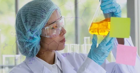 Scientist holding orange flask in her hand. Stock Footage 107975802