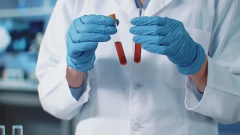 Scientist holding test tubes in a laboratory doing research. Stock Footage 311082740