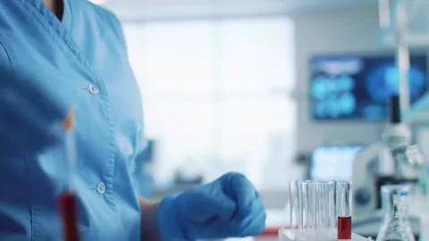 Scientist holding test tubes in a laboratory doing research. Stock Footage 311082741