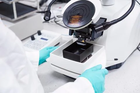 Scientist inserts the sample for biological analysis into the microscope Stock Photos