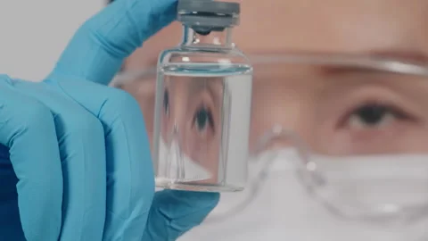 Scientist Inspecting Clear Liquid Vial in Modern Laboratory, Close-up Vídeos de archivo 335138161