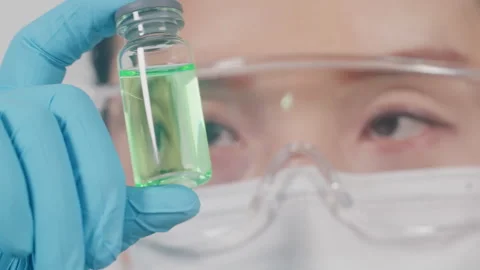 Scientist Inspects Green Liquid Sample in Laboratory, Close-up Shot 库存影片 335138136