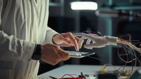 Scientist interacting with a robotic hand while conducting technology resear Stock Footage 323931680