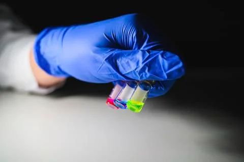 Scientist investigating three colourful solution in different LCMS glass vial Stock Photos