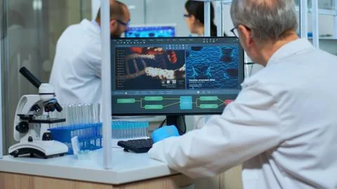 Scientist in lab coat working at a computer in laboratory Stock Photos