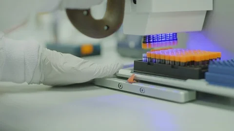 A scientist in a lab taking samples with ultraviolet light machine Stock Footage 106423857