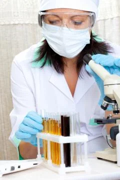 Scientist in laboratory analyzing yellow liquid in test tube Foto stock
