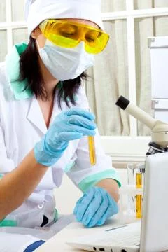 Scientist in laboratory analyzing yellow liquid in test tube Stock Photos