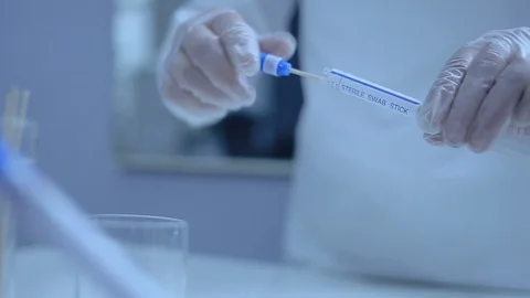 Scientist in Laboratory- Coronavirus test tubes for swabbing Stockbeeldmateriaal 128990452